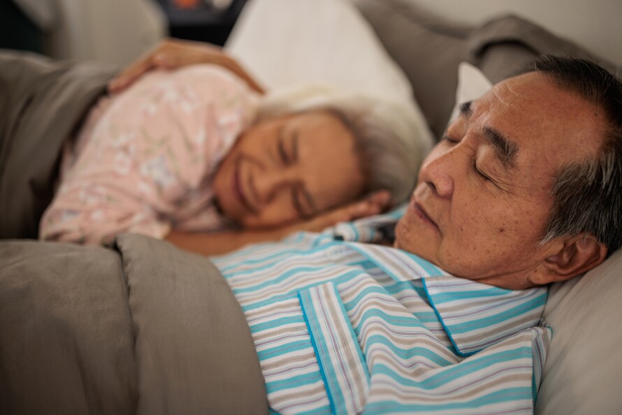 African American grandchild and grandfather read a book together at home